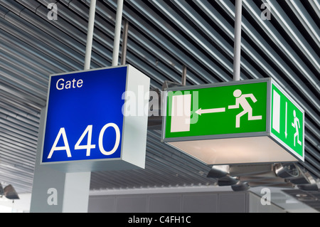 Grüne Notausgang unterzeichnen, und blauen Tor im Flughafen Stockfoto