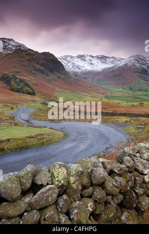 Eine kurvenreiche Bergstrasse hinab in Great Langdale Valley, Lake District National Park, Cumbria, England. Stockfoto