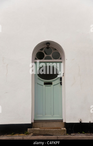 Eine altmodische Haustür in ein Haus in Lyme Regis, Dorset. Die Tür ist gewölbt und hat Verglasung über der Tür. Stockfoto