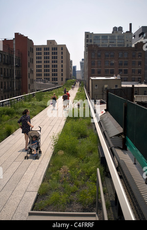 Frau mit Kinderwagen und andere gehen auf Abschnitt 2 der High Line Park in New York City, USA. © Craig M. Eisenberg Stockfoto