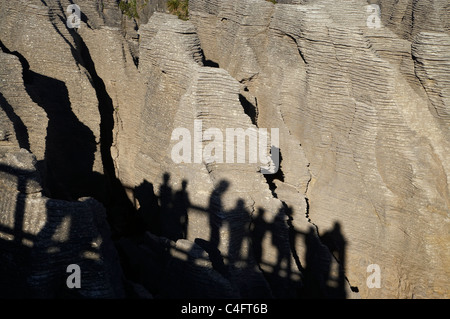 Schatten der Besucher auf die Pancake Rocks in Punakaiki im Paparoa-Nationalpark, West Coast, Südinsel, Neuseeland Stockfoto