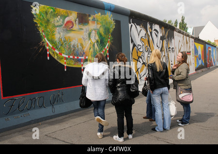 Eine Gruppe von Menschen, die Blick auf die Gemälde in der East Side Gallery in Berlin Stockfoto