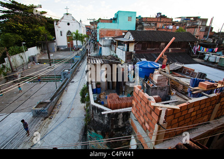 Alltag in Morro da Providencia Favela in Rio De Janeiro Innenstadt. Mann baut Hausbau auf der Deckplatte Stockfoto