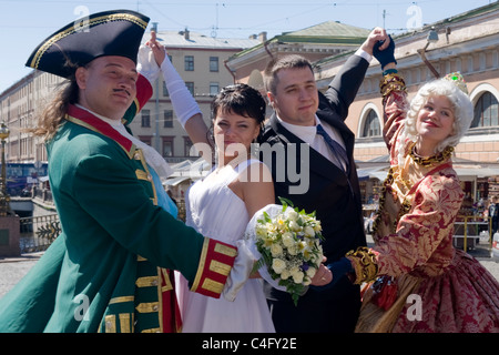 Typische Straßenszene in Russland, St. Petersburg, eine andere Braut & Bräutigam & ein weiterer Mann & Frau im Kostüm posiert für Fotos Stockfoto