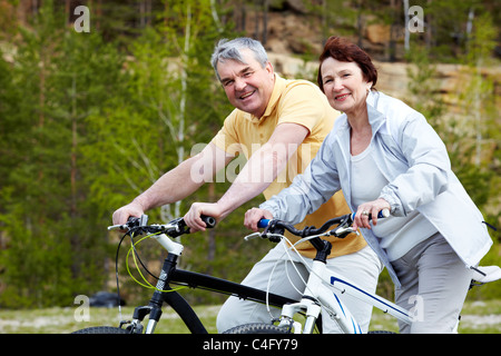 Porträt von glücklich älteres Paar auf Fahrrädern Stockfoto