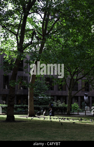 Dieser öffentliche Park wo drei Obdachlose Männer im Schatten der Platanen London entspannen liegt im Victoria Street. Stockfoto