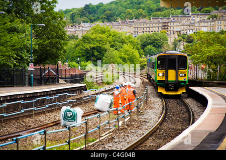 Railtrack Arbeitnehmer, die auf Schienen am Bahnhof Bath Spa als ein Zug in fährt. Stockfoto