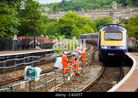 Railtrack Arbeitnehmer, die auf den Schienen am Bahnhof Bath Spa als ein Zug durch fährt Stockfoto