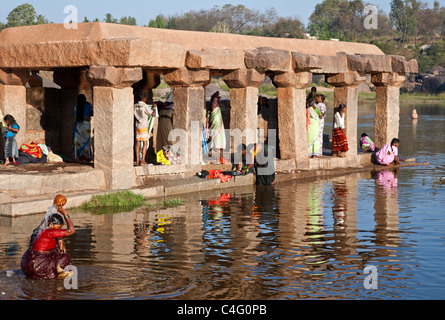 Frauen Baden und die Wäsche machen. Tungabhadra Fluss. Hampi. Karnataka. Indien Stockfoto