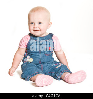 Ein nettes 1 Jahr alten Baby Mädchen mit blauen Augen tragen Jeans und rosa lächelnd vor dem Hintergrund von reinem weiß (255). Stockfoto