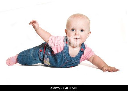 Ein nettes 1 Jahr alten Baby Mädchen mit blauen Augen tragen Jeans und rosa lächelnd vor dem Hintergrund von reinem weiß (255). Stockfoto