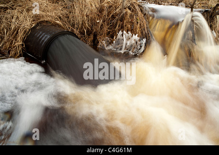 Drainpipe spuckt schwarzes Wasser aus, Finnland Stockfoto