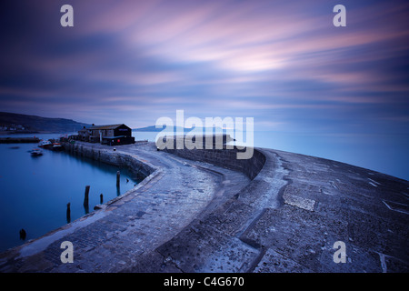 Die Cobb bei Lyme Regis im Morgengrauen mit der Jurassic Coast darüber hinaus, Dorset, England, UK Stockfoto