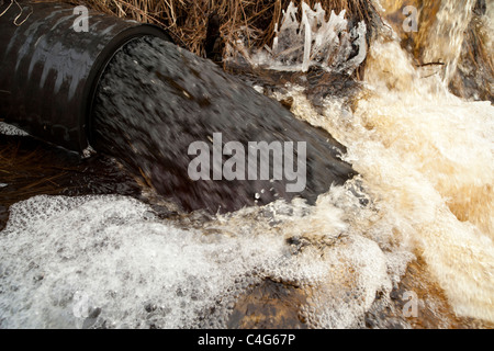 Drainpipe spuckt schwarzes Wasser aus, Finnland Stockfoto