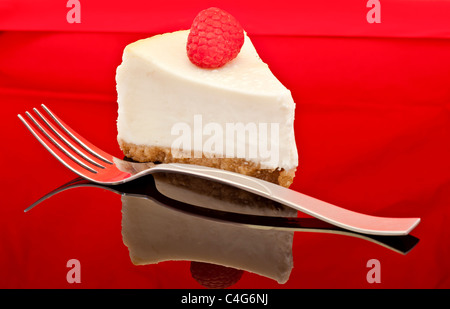 Vanille-Käsekuchen auf gespiegelten schwarze Acrylplatte mit Rote Himbeere und Silber Gabel sowie Reflexion. Stockfoto