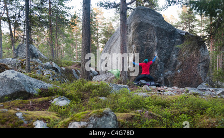 Ein männlicher Felsen Kletterer Bouldern in der Nähe von Luleå, Schweden Stockfoto