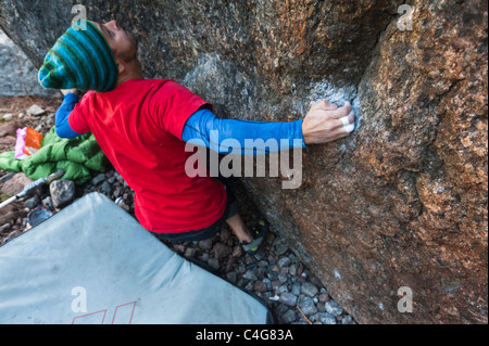 Ein männlicher Felsen Kletterer Bouldern in der Nähe von Luleå, Schweden Stockfoto