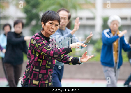 Eine ältere chinesische Dame während eines frühen Morgens Tai Chi Sitzung in Mongkok auf der Halbinsel Kowloon, Hong Kong Stockfoto