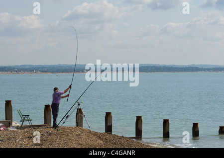 Meer Angler Angeln an Pevensey Bay, East Sussex, England Stockfoto