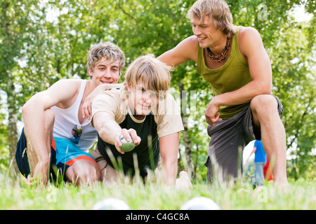 Gruppe junger Männer spielen Boule in einem Park im Freien im Sommer Stockfoto