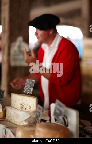 ein Mann verkauft Käse auf dem Markt in Revel, Languedoc, Midi-Pyrenäen, Frankreich Stockfoto