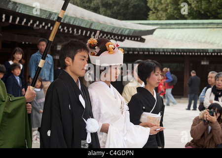 Braut, Bräutigam und andere Hochzeit Partei Mitglieder am Meiji-Jingu Schrein mit Zuschauern im Hintergrund, Shibuya, Tokyo, Japan, Asien. Stockfoto