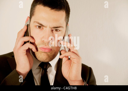 Junger Mann mit zwei Handys. Stockfoto