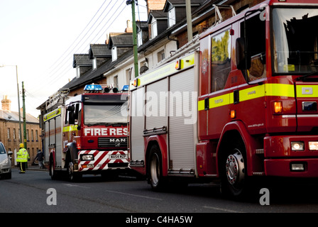 Zwei rote Feuerwehrfahrzeuge, Teilnahme an einem Hausbrand, Devon England UK Stockfoto