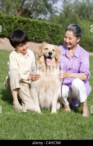Großmutter und Enkel spielen mit Hund Stockfoto