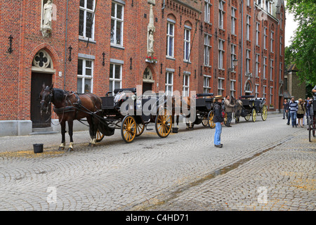 Horse-drawn Wagen an ihren Einkehrschwung in Wijngaardplein, Brügge, Belgien. Stockfoto