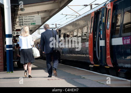 Passagiere und Zug am Bahnhof in England Stockfoto