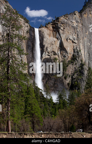 Yosemite National Park uns Wasserfälle Bridalveil Falls seidig Frühling voller Durchsatz, Nebel, die an der Basis über Bäumen, bezeichnendes Licht auf Felswand niedrigen Winkel Stockfoto