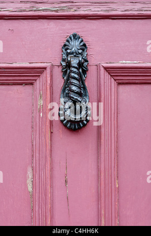 Wrought Eisen Türklopfer an Rosa Tür Stockfoto