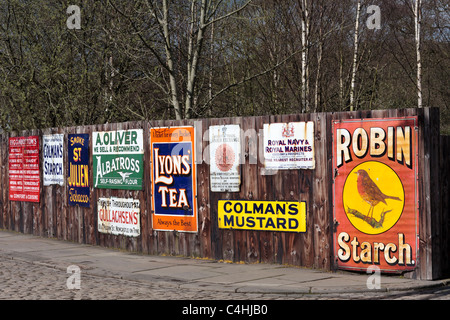 Alte emaillierte Werbeschilder auf einem Holzzaun beamish Museum in Durham, england Stockfoto