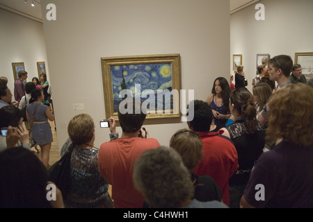 Besucher drängen sich um "Sternennacht" eines der bekanntesten Gemälde der Welt, von Vincent Van Gogh im MOMA, New York City. Stockfoto