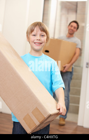 Jungen mit jungen Mann am Tag tragen Kartons Umzugskarton Stockfoto