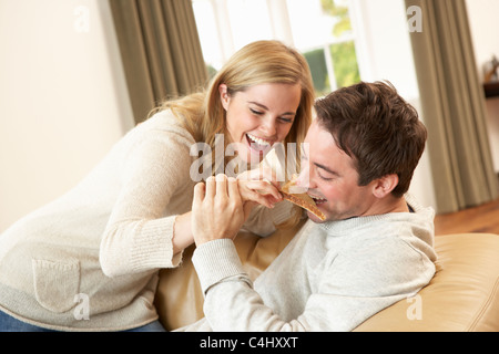 Junge Paare, die Spaß am Sofa lachen Stockfoto