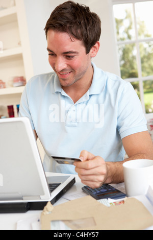 Junger Mann mit Kreditkarte über das internet Stockfoto