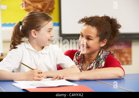 Schulmädchen In Klassenzimmer mit Lehrer studieren Stockfoto