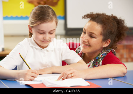 Schulmädchen In Klassenzimmer mit Lehrer studieren Stockfoto