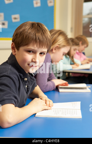 Schuljunge Lesebuch im Klassenzimmer Stockfoto