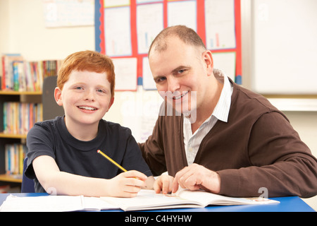 Männliche Schüler lernen im Klassenzimmer mit Lehrer Stockfoto