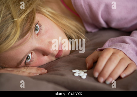 Depressive Teenager-Mädchen sitzen im Schlafzimmer mit Pillen Stockfoto