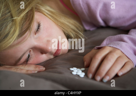 Depressive Teenager-Mädchen sitzen im Schlafzimmer mit Pillen Stockfoto