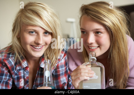 Zwei Mädchen im Teenageralter auf Sofa sitzen zu Hause trinken Alkohol Stockfoto