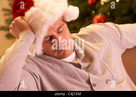 Vor Weihnachtsbaum entspannen müde Mann Stockfoto