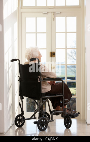 Behinderte ältere Frau sitzt im Rollstuhl Stockfoto