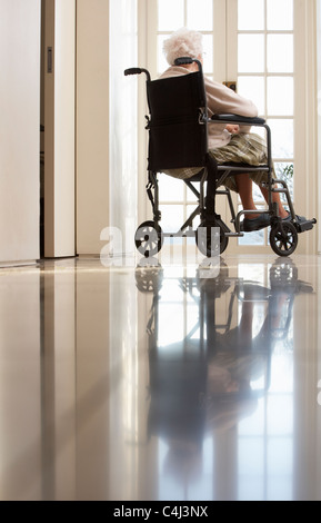 Behinderte ältere Frau sitzt im Rollstuhl Stockfoto