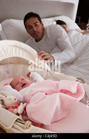 Neugeborenes Baby weint im Kinderbett im Zimmer der Eltern Stockfoto