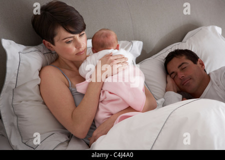 Mutter kuscheln neugeborenes Baby im Bett zu Hause Stockfoto